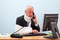 Injured businessman at his desk on the phone Royalty Free Stock Photo