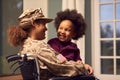 Injured Female American Soldier Wearing Uniform Sitting In Wheelchair Holds Hugging Daughter