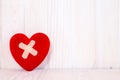 Injured heart on the white wooden background