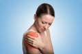 Injured joint. Woman patient in pain having painful shoulder colored in red.