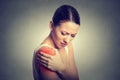 Injured joint. Woman patient in pain having painful shoulder colored in red Royalty Free Stock Photo