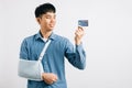A confident man copes with a broken arm, using credit card
