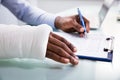 Injured Man Filling Insurance Claim Form Royalty Free Stock Photo