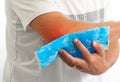 Injured Man using reusable ice gel packs his elbow, medical first aid after accident.