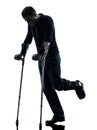 Injured man walking with crutches silhouette