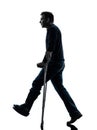 Injured man walking with crutches silhouette