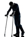 Injured man walking sad with crutches silhouette