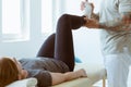 Injured patient and physiotherapist doing muscle stretching exercises