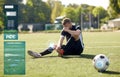 Injured soccer player with ball on football field