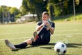 Injured soccer player with ball on football field