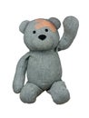 Injured Teddy Bear with plasters on head greetings hand up isolated