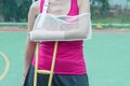 Injured woman broken arm and leg holding crutch Royalty Free Stock Photo