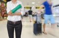 Injured woman with green cast on hand and arm on traveler in motion blur in airport interior background, ,body injury concept Royalty Free Stock Photo