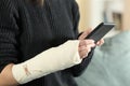 Injured woman hands with bandaged arm using phone Royalty Free Stock Photo
