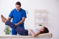Injured woman visiting young male doctor osteopath