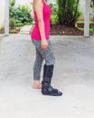 injured woman wearing sportswear with black ankle brace on leg s