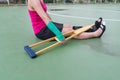 Injured woman wearing sportswear painful arm with gauze bandage, arm cast and wooden crutches sitting on floor Royalty Free Stock Photo