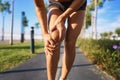 Injuries - sports running knee injury on woman. young woman with injured knee or leg outdoors. Royalty Free Stock Photo