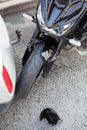 Injury by collision of motorcycle and car, close up view of road accident with broken parts of plastic fender Royalty Free Stock Photo