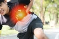 Injury concept. man suffering chest pain while jogging exercise in public park