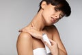 Injury Treatment. Beautiful Woman With Neck Pain Applies Cream
