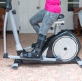 injury woman with black cast on leg sitting on exercise bike at