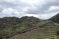 Inka ruins with Andens, stair-step like agricultural terrace dugs into the slope of a hillside in Pisac Archeological park, Peru