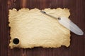 Old paper and inkstand with quill pen on a wood background