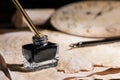 Inkwell with fountain pen on vintage parchment, closeup. Space for text Royalty Free Stock Photo