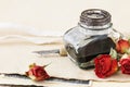 Inkwell, pen and dried roses on vintage paper background. Love letters idea Royalty Free Stock Photo