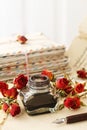 Inkwell, pen and dried roses on vintage paper background. Love letters idea Royalty Free Stock Photo