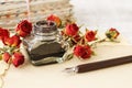 Inkwell, pen and dried roses on vintage paper background. Love letters idea Royalty Free Stock Photo