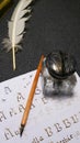 Inkwell with quill, quill, nib and sheet with gothic letters Royalty Free Stock Photo