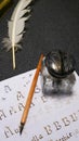 Inkwell with quill, quill, nib and sheet with gothic letters