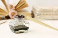 Inkwell and vintage pen. Open book in the background Royalty Free Stock Photo