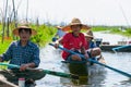 Inle Lake locals paddling traditional boats along channel