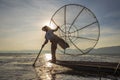 Burmese fisherman on bamboo boat catching fish in traditional way with handmade net. Inle lake, Myanmar, Burma Royalty Free Stock Photo