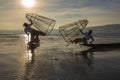 Burmese fisherman on bamboo boat catching fish in traditional way with handmade net. Inle lake, Myanmar, Burma Royalty Free Stock Photo