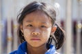 A young girl from Myanmar with Tanaka on her face in yard near local school, Burma