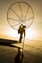 Burmese fisherman on bamboo boat catching fish in traditional way with handmade net. Inle lake, Myanmar, Burma Royalty Free Stock Photo