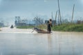 Inle / Myanmar - Jan 14, 2014 : Burmese men wearing white shirts and hats, paddling on the canals in the morning