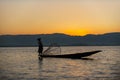Inle / Myanmar - Jan 14, 2014 : Silhouette of a burmese man wearing a hat Use the rowing legs to catch fish in the evening