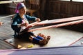 Inle, Myanmar - March 2019: Kayan Lahwi tribe long neck woman sits behind the loom