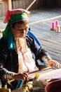 Inle, Myanmar - March 2019: Kayan Lahwi tribe long neck woman sits behind the loom