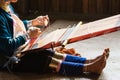 Inle, Myanmar - March 2019: Kayan Lahwi tribe long neck woman sits behind the loom