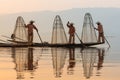 Inle, Myanmar - March 2019: three traditional Burmese leg rowing fishermen at Inle lake