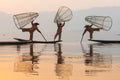 Inle, Myanmar - March 2019: three traditional Burmese leg rowing fishermen at Inle lake