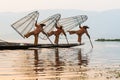 Inle, Myanmar - March 2019: three traditional Burmese leg rowing fishermen at Inle lake Royalty Free Stock Photo