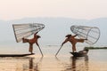 Inle, Myanmar - March 2019: two traditional Burmese leg rowing fishermen at Inle lake Royalty Free Stock Photo