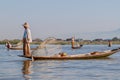 INLE, MYANMAR - NOVEMBER 28, 2016: Local fishermen at Inle lake catching fish in a traditional way with handmade ne Royalty Free Stock Photo